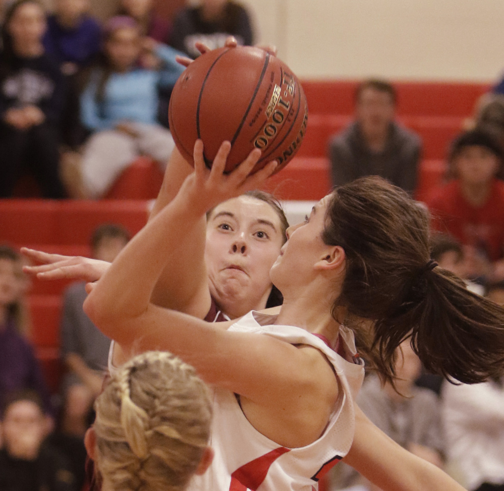 Mackenzie Holmes of Gorham blocks a shot by South Portland’s Maddie Hasson during a Class AA South girls’ basketball game Friday in South Portland. Gorham improved to 3-0 with a 40-38 victory.