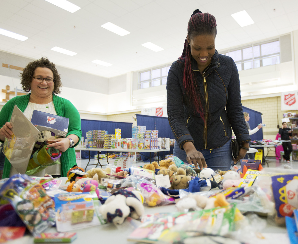 Viola Lupai looks through stuffed animals at the Salvation Army’s toy distribution program, funded by kettle donations, as volunteer Jessica Nason helps her. The Salvation Army raised its fundraising goal this year to meet needs in Maine.