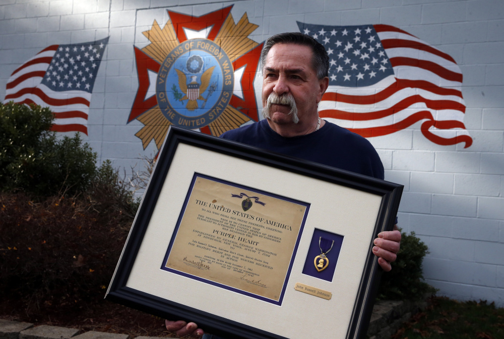 Jim Doherty, 66, of Holbrook and post commander of VFW Post 1046, holds the Purple Heart found by a teenage girl inside the Brockton (Mass.) VFW Post. (Jessica Rinaldi/The Boston Globe via AP)