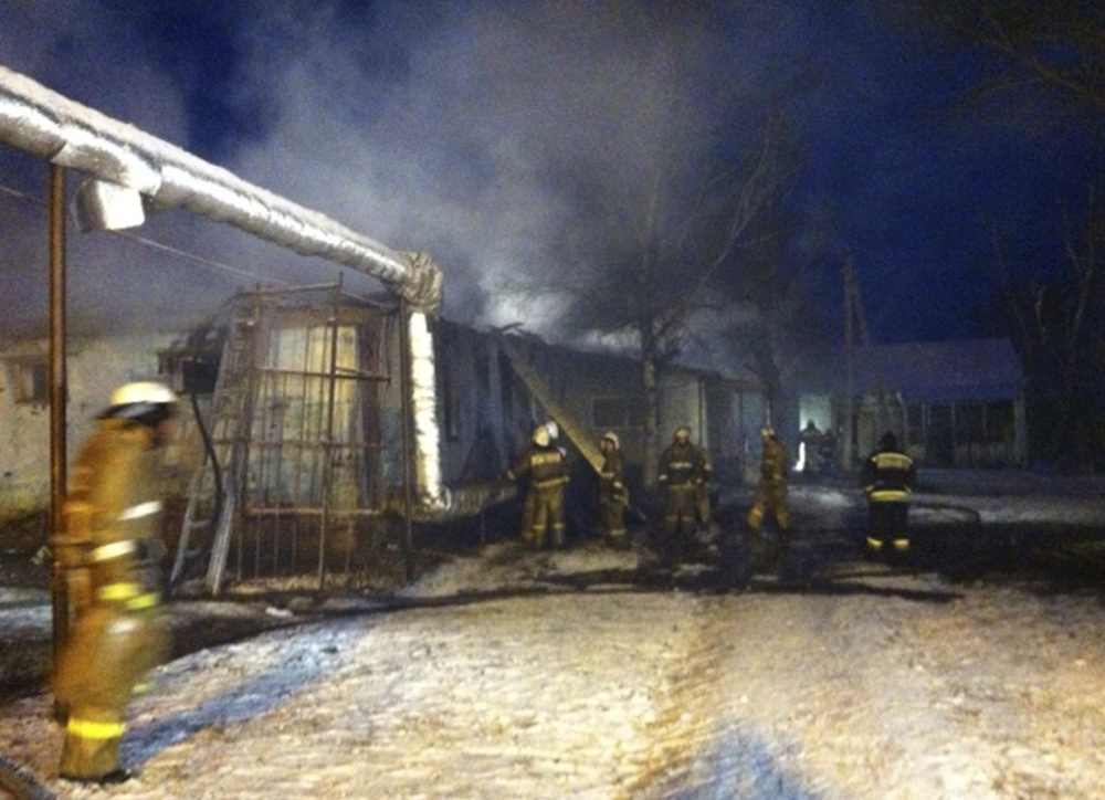 Firefighters work to put out a blaze at a Russian home for people with mental illness in Alferovka, about 350 miles south of Moscow. Russian emergency services say 23 people died.