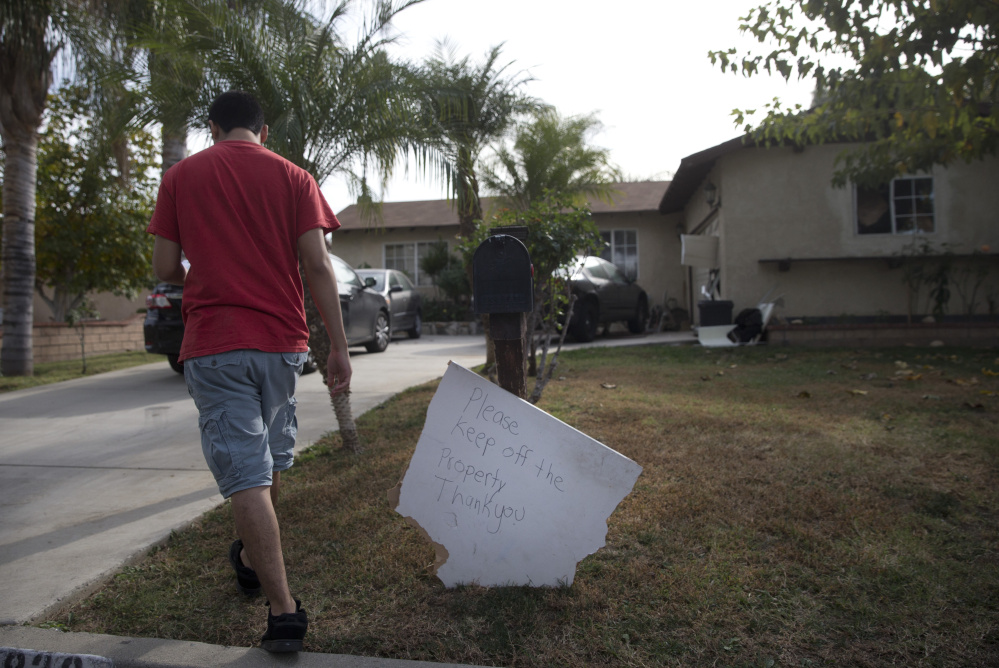 A brother of Enrique Marquez walks toward the family home on Wednesday in Riverside, Calif. Investigators are trying to piece together what Marquez knew about the San Bernardino attacks.