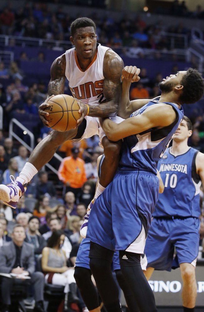 Eric Bledsoe of the Suns looks to make a pass while being defended by Minnesota’s Karl-Anthony Towns during the Suns’ 108-101 win Sunday in Phoenix.