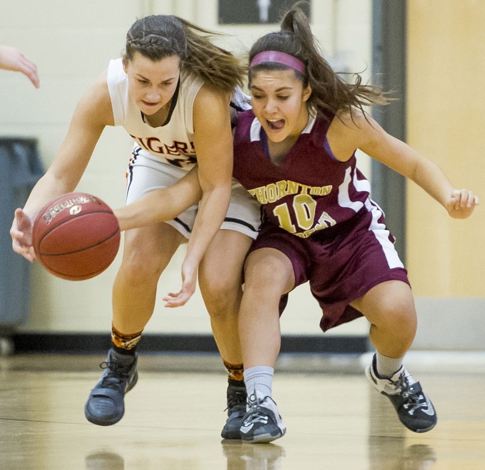 Biddeford’s Taylor Wildes, left, and Adeline Paradis of Thornton Academy fight for control of the ball during a girls’ basketball game Monday in Biddeford. Thornton Academy won, 58-27.