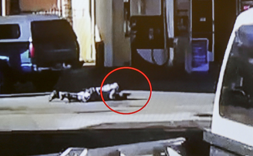 Nicholas Robertson is stretched out on the ground with a gun in his hand after he was shot by sheriff’s deputies Saturday. The deputies fired at Robertson more than 30 times.