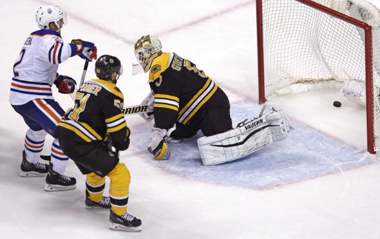 Edmonton’s Andrej Sekera beats Bruins goalie Jonas Gustavsson for the game-winning goal in overtime. At center is Bruins center Ryan Spooner.