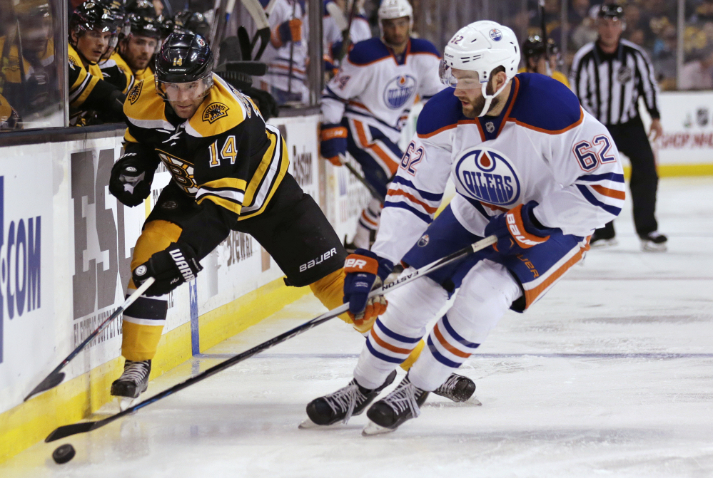 Oilers defenseman Eric Gryba strips the puck from Bruins right wing Brett Connolly in the second period of Edmonton’s overtime win Monday night in Boston.