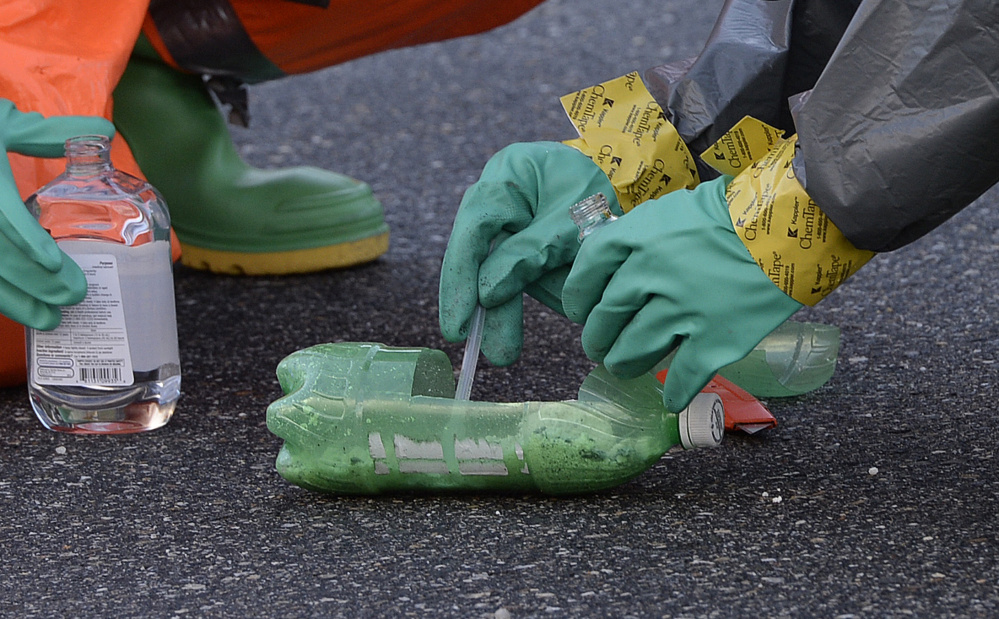 Drug enforcement agents take samples from a “one-pot” bottle that was found in the trash outside the home at 125 Old Thompson Road in Buxton. The evidence was moved to the town’s public works facility, where it was evaluated.