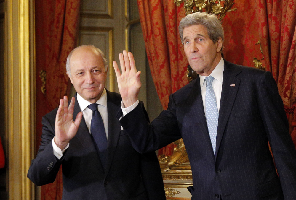 U.S. Secretary of State John Kerry, right, and  French foreign minister Laurent Fabius greet the media before a meeting in Paris on Monday.
The Associated Press