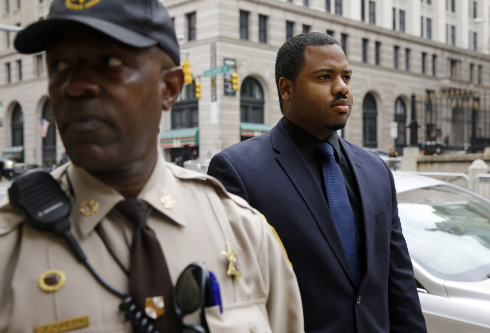 Officer William Porter, right, one of six Baltimore police officers charged in the death of Freddie Gray, walks into the courthouse during jury deliberations Wednesday in Baltimore. Jurors could not reach a verdict in the case so the judge declared a mistrial.