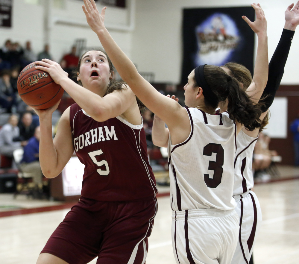 Mackenzie Holmes of Gorham focuses on the basket while shooting over Moira Train, right, and Maddie Cyr of Greely. Holmes scored her 12 points in the first quarter for the Rams.