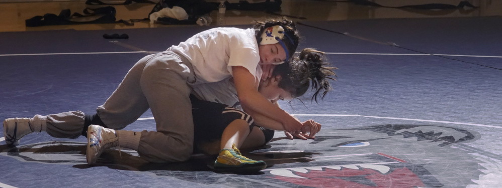 Nursing drew Samantha Frank, top, to Orono, and while she’s still pursuing it as a career, she also finds fullfillment with the school’s club wrestling program, as does Leticia Souza, who’s going to need some kind of move to escape this hold.