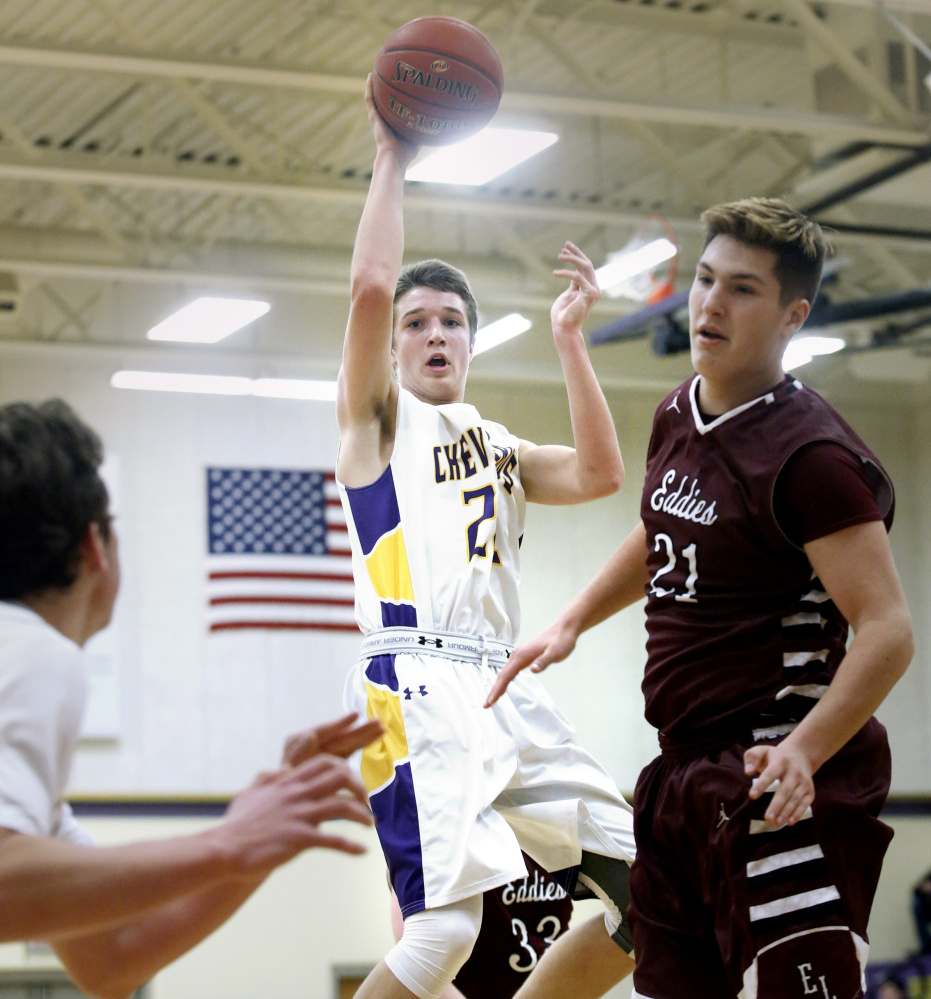 Jack Casale of Cheverus finds a teammate under the basket as Grant Hartley of Edward Little looks to defend during a boys’ basketball game in Portland Friday night. Casale led the Stags with 16 points in a 52-40 victory.