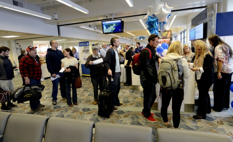 Passengers line up to board the first Elite Airways flight to Florida from the Portland International Jetport on Friday. The state draws 67.4 million domestic visitors a year, a representative from Visit Florida says. Shawn Patrick Ouellette/Staff Photographer