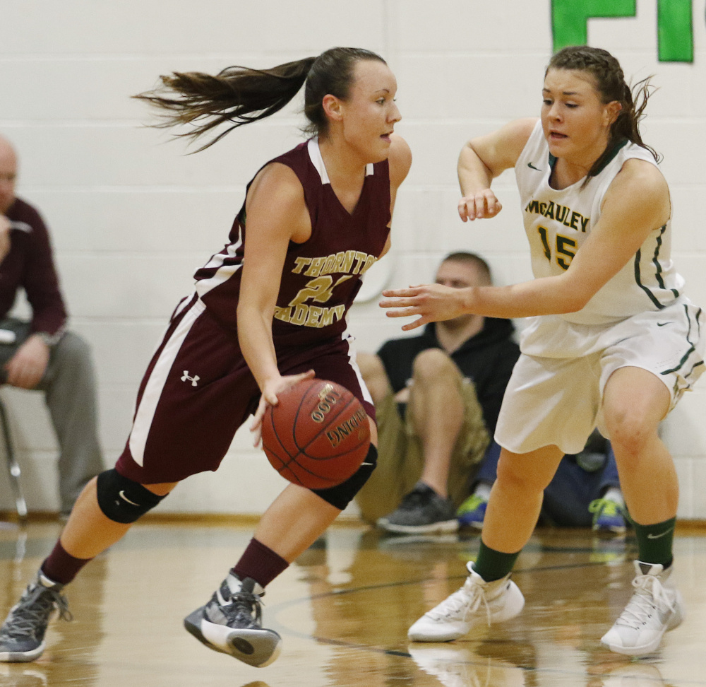 Thornton Academy’s Isabella Robinson drives against Brooke Howard of McAuley during a Class AA South showdown Friday night. McAuley won the rematch of last year’s Western Class A final, 41-31.