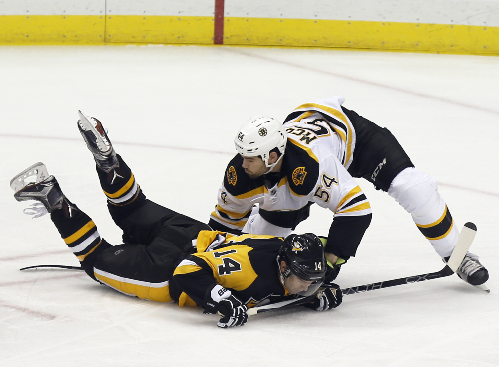 Boston’s Adam McQuaid keeps the Penguins’ Chris Kunitz face-down on the ice during the Bruins’ 6-2 victory Friday night in Pittsburgh.