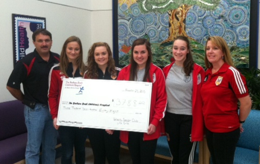 Velocity Soccer Club coach Rick Doyon and team members, from left, Natalia Profenno of Saco, Sarah Champagne of Buxton, Erin Gorton of Kennebunk and Camryn Morton of Gorham, and coach Laurie Holbrook present the team’s donation of $3,788 to the Barbara Bush Children’s Hospital at Maine Medical Center in Portland.