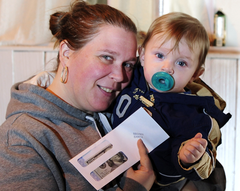 Tammy Graffam holds her gift and her 1-year-old grandson Blake Guerrette at the food pantry in Alfred on Monday.