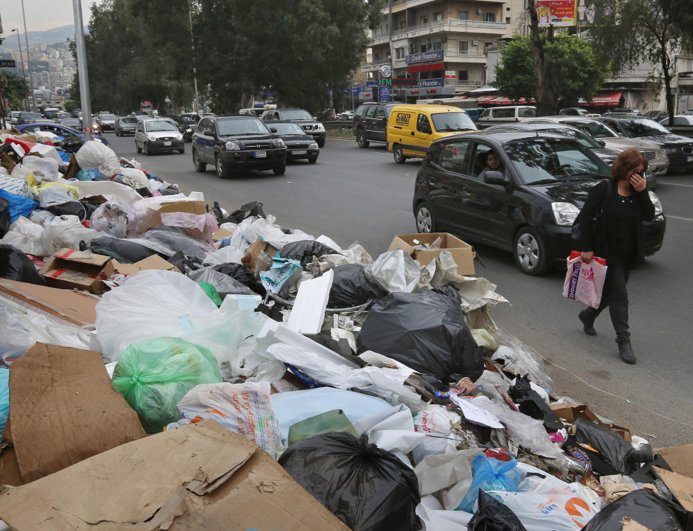 A Lebanese woman covers her nose from the smell as she passes by a pile of garbage on a street in eastern Beirut. The six-month build-up of trash began after Beirut’s primary landfill was closed down, but no alternative for disposal was provided.