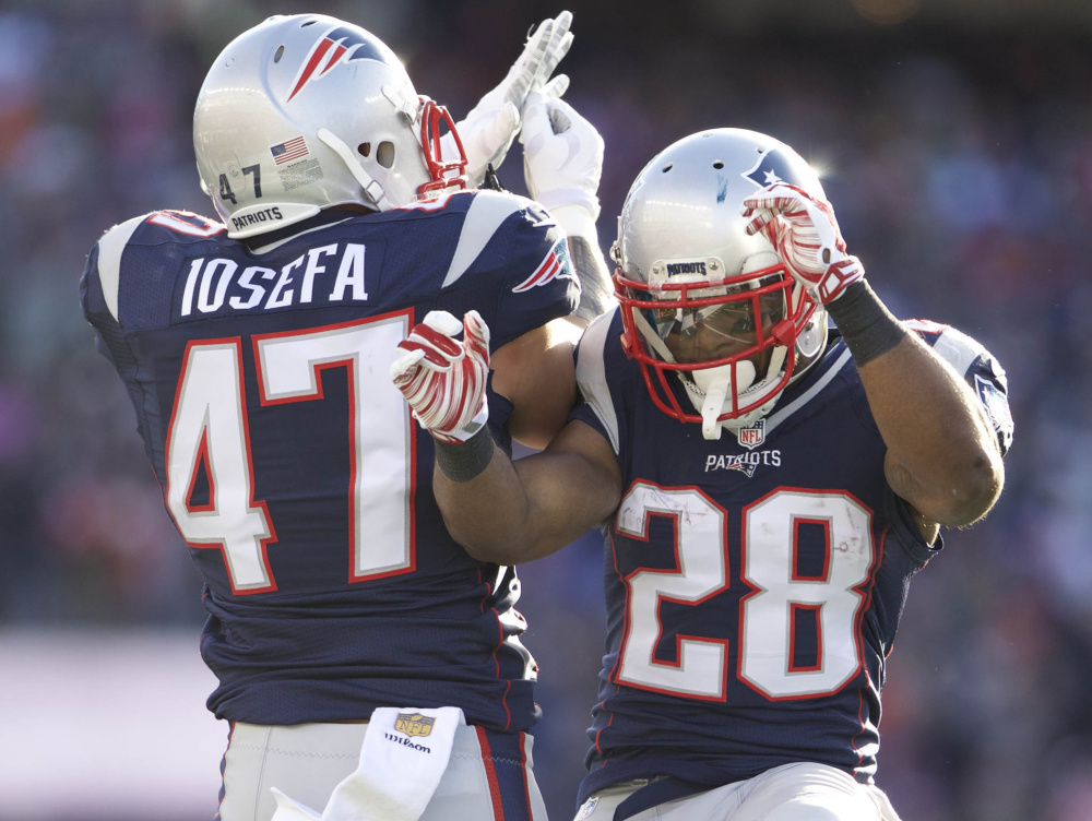 Patriots running back James White, right, is congratulated by running back Joey Iosefa after White scored a 30-yard touchdown Sunday.