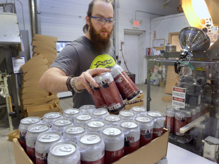 A booming microbrewery industry has led to a shortage of the humble beer can. That's left Maine brewers scrambling to plan for the busy summer 
 season. Rising Tide Brewery employee Eric Altman loads four-packs of beer into cases during a canning run at the Portland brewery Monday.
John Ewing/Staff Photographer