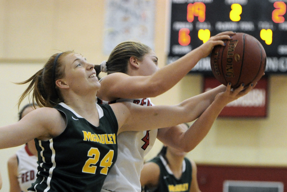 Emily Weisser of McAuley, left, battle for a rebound with Brooke Malone of Scarborough during Tuesday night’s game in Scarborough.