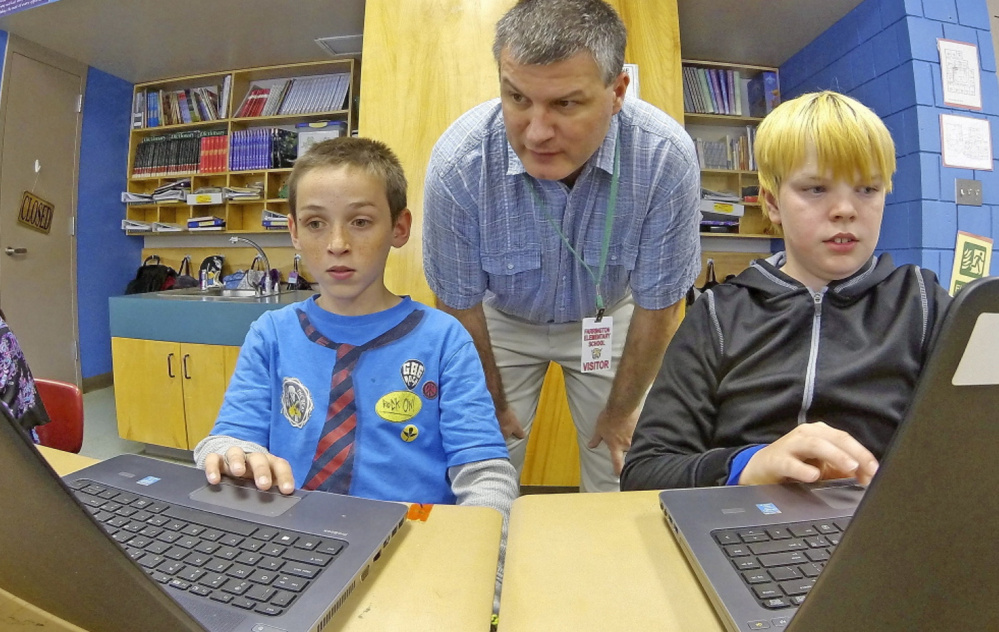 Kepware Technologies CEO Tony Paine, shown overseeing Augusta’s Farrington Elementary School fourth-graders Gabriel Biasuz, left, and Jared Barker, who are using laptops that his company donated, says the impending sale won’t affect Kepware’s local footprint.