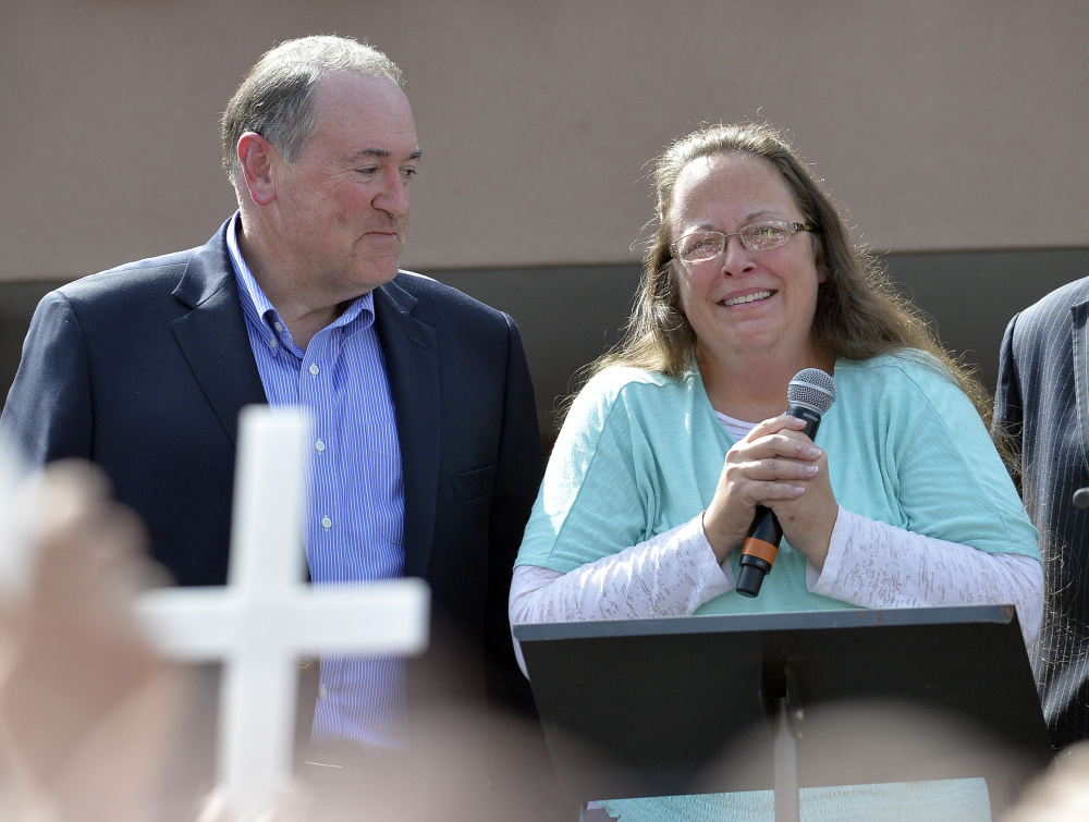 Rowan County Clerk Kim Davis, with Republican presidential candidate Mike Huckabee, left, at her side, speaks after being released from the Carter County Detention Center, Tuesday, Sept. 8, 2015, in Grayson, Ky. Davis, the Kentucky county clerk who was jailed for refusing to issue marriage licenses to gay couples, was released Tuesday after five days behind bars.   (AP Photo/Timothy D. Easley)