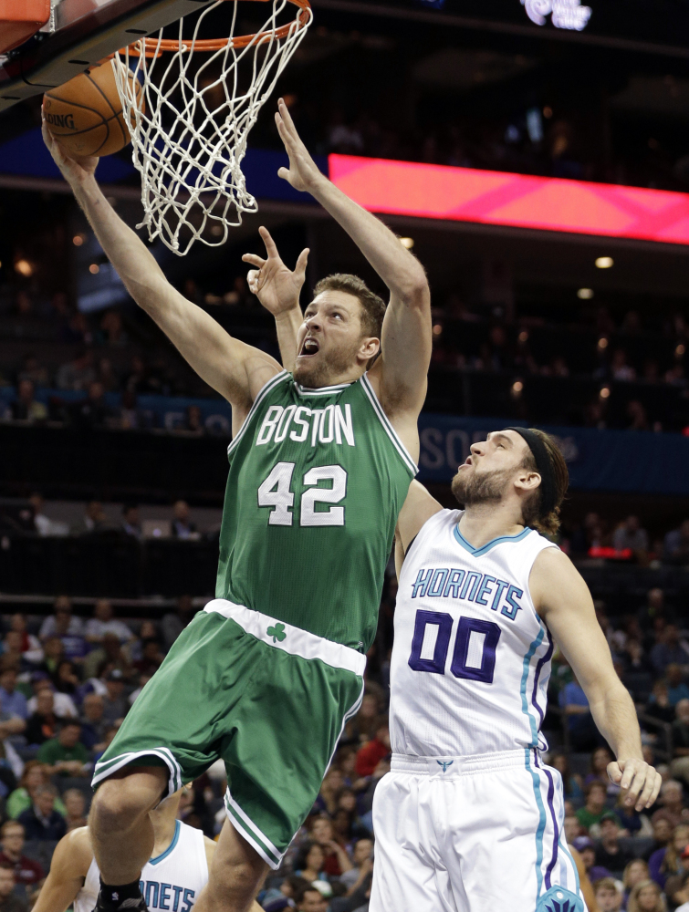 The Celtics’ David Lee drives past Charlotte’s Spencer Hawes in the first half. Lee finished with 10 points in the game.