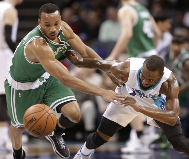 The Charlotte Hornets’ Kemba Walker and the Celtics’ Avery Bradley chase the ball in the first half of Boston’s win Wednesday night in Charlotte. Bradley scored 18 points for the Celtics.