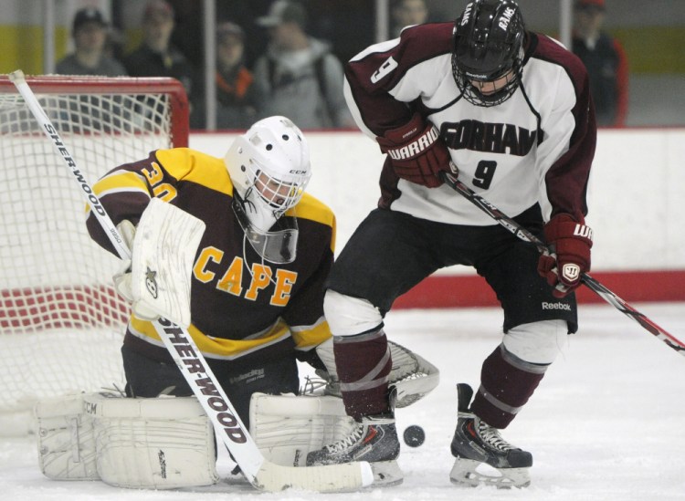 Cape Elizabeth goalie Grant Rusk holds his ground Wednesday as Holden Edwards of Gorham attempts to redirect a shot into the net. Cape Elizabeth won, 5-1.