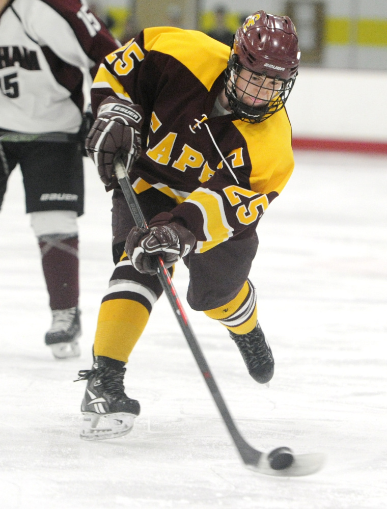 Eli Babcock of Cape Elizabeth keeps his eyes on the puck while sending a shot on goal. Babcock finished with two assists against Gorham.