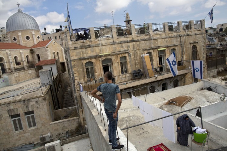 A Palestinian woman takes down laundry on her balcony facing a Jewish seminary in Jerusalem’s Old City Muslim Quarters. Jews can’t afford to be a minority in Israel by allowing a full right of return to refugees, a reader says.