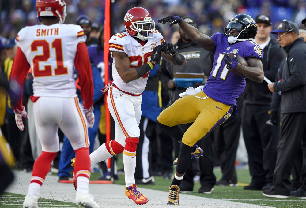 Kansas City Chiefs free safety Eric Berry, center, pushes Baltimore Ravens wide receiver Kamar Aiken out of bounds as teammate Sean Smith (21) watches in the first half on Dec. 20 in Baltimore. The Associated Press