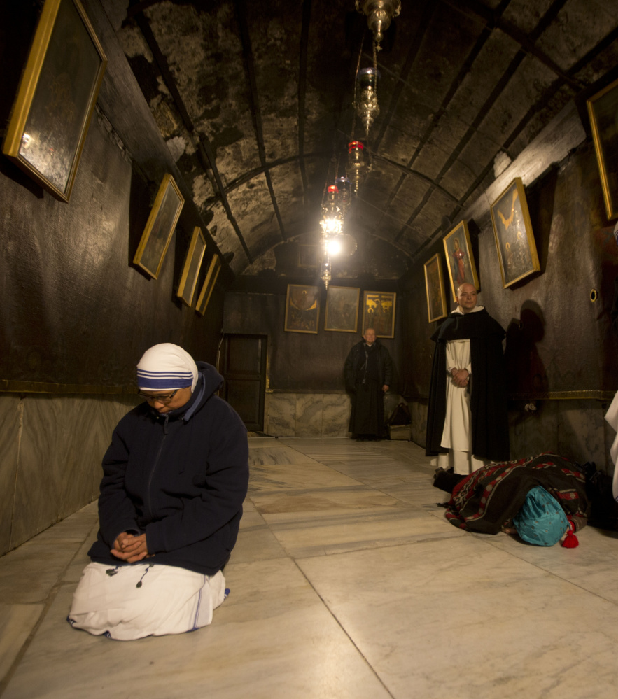 A nun prays inside the Grotto at the Church of the Nativity in Bethlehem. Months of Israeli-Palestinian violence have cast a pall over Christmas celebrations.