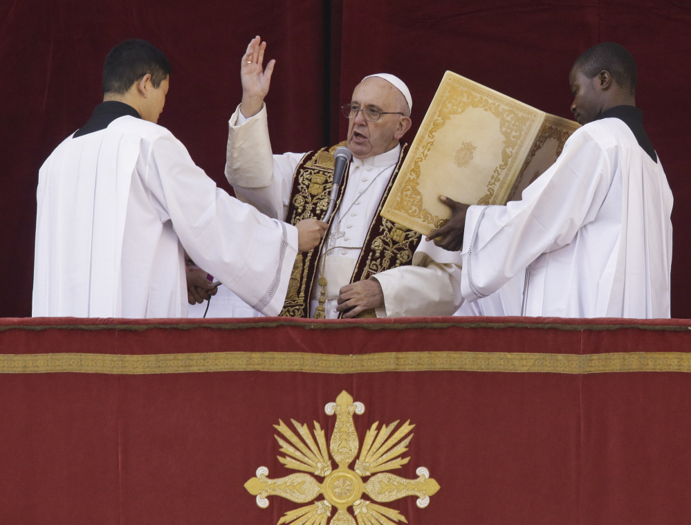 Pope Francis delivers his “Urbi et Orbi” (to the city and to the world) blessing from the central balcony of St. Peter’s Basilica at the Vatican on Friday.