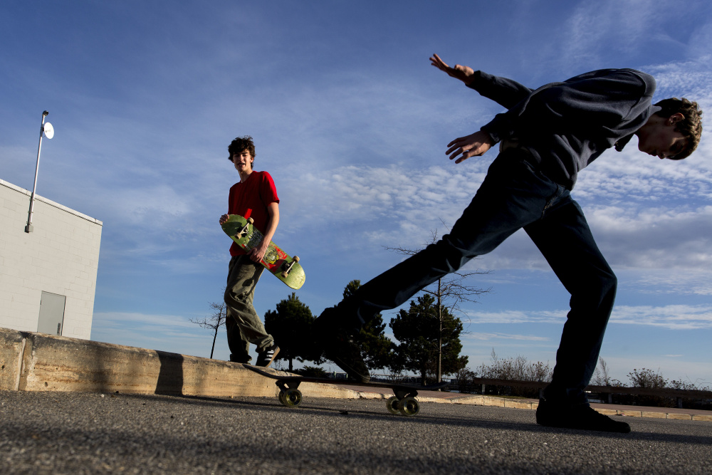 Gabe Souza/Staff Photographer
Aidan Parker, 16, looks on as his brother Julian Parker, 14, skates off a sidewalk at Ocean Gateway Terminal in Portland on Friday.