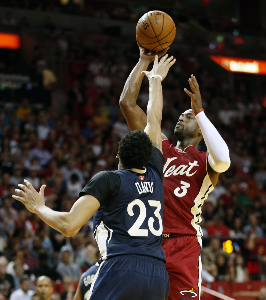 Miami’s Dwyane Wade shoots against New Orleans’ Anthony Davis during the second half of Friday’s game in Miami, won by the Heat, 94-88 in overtime.