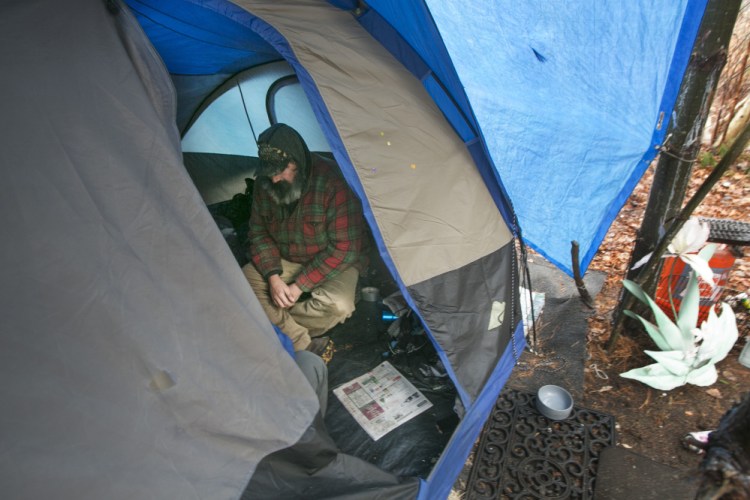 A homeless man shelters in a tent on the outskirts of Portland to get out of the rain Dec. 17. Two readers are troubled by the influx of homeless camps along land trust trails.