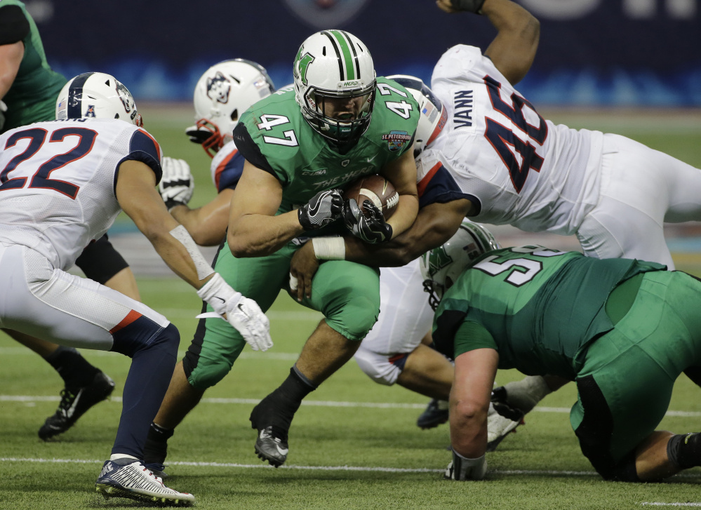 Devon Johnson of Marshall sprints through the Connecticut line during their St. Petersburg Bowl game in Florida. Marshall came away with a 16-10 victory and finished with a 10-3 record.