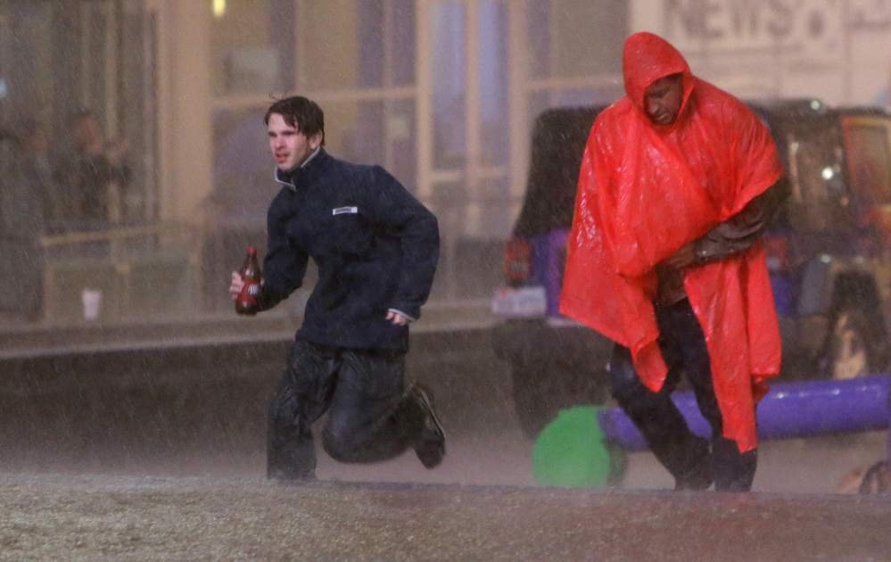 People run as weather sirens sound as a severe storm passes over downtown Dallas on Saturday. 