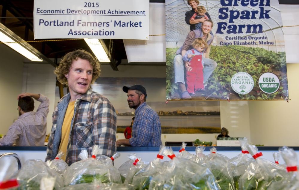 Austin Chadd, owner of Green Spark Farm of Cape Elizabeth, awaits customers at the farmers market.