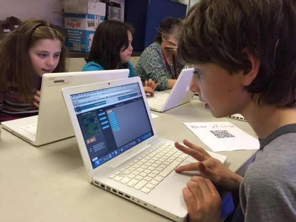 Ryan Chase, right, Tabitha Boudle, left, and Kelci Nguyen, students at the Wells-Ogunquit Community School District, participate in a computer programming session called “Hour of Code.”  The program was held in conjunction with Computer Science Education Week.