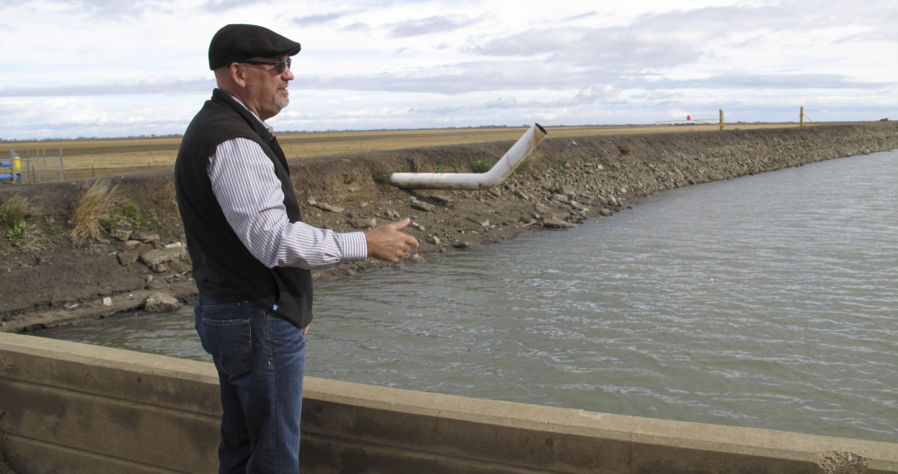 Chris White, general manager of the Central California Irrigation District, explains the expense – which has already soared into the millions of dollars in his district – of fixing infrastructure damaged by the sinking of land near Dos Palos, Calif.
