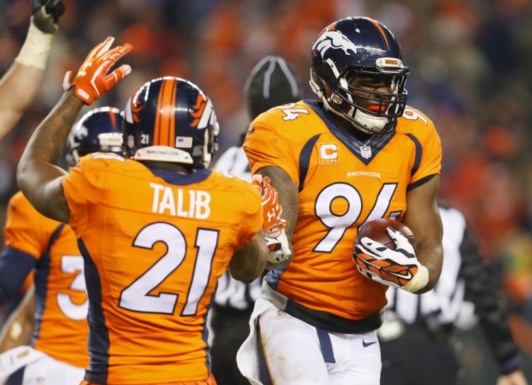 Denver linebacker DeMarcus Ware (94) celebrates his fumble recovery, which sealed the Broncos’ win over the Cincinnati Bengals in overtime Monday night.
