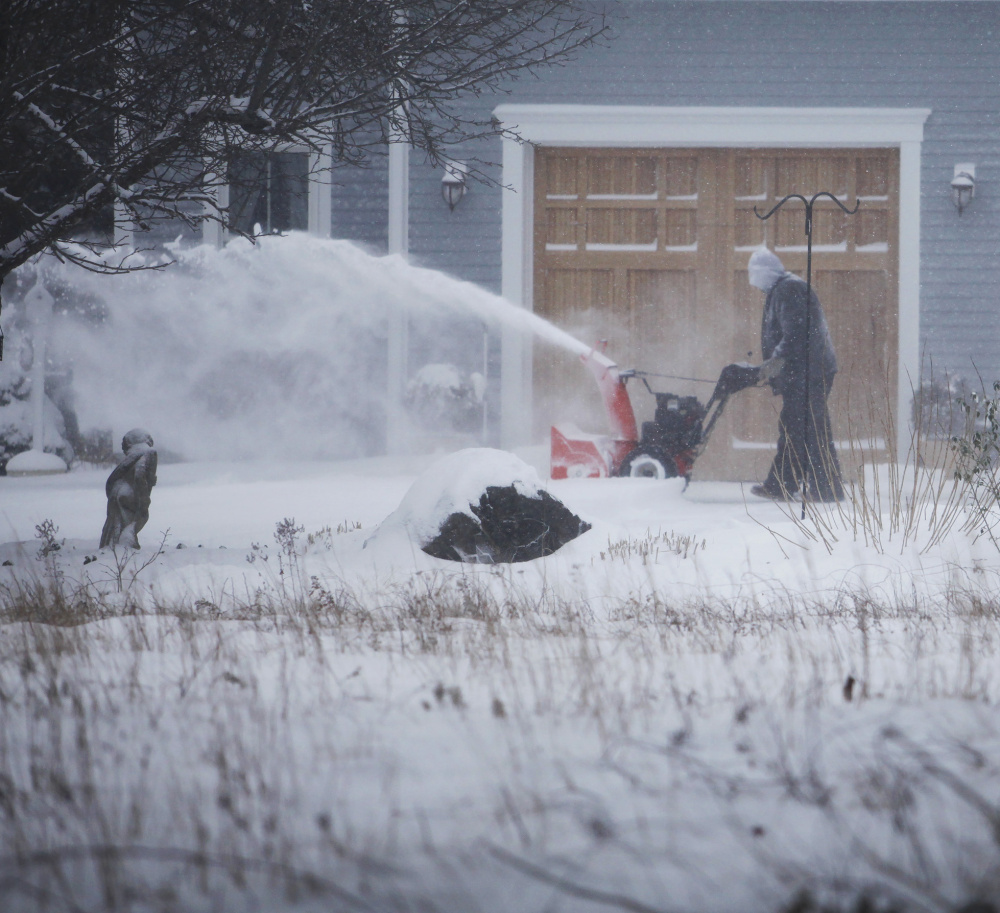 Fred Papandrea battles wind and cold as he clears his driveway in Wells during Tuesday’s storm. The transition to winter was jarring after weeks of unseasonable warmth.