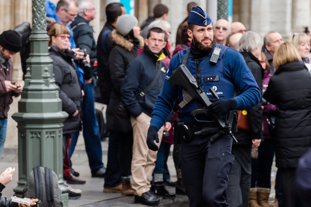 An armed officer patrols at the Grand Place in Brussels on Tuesday. Two people have been arrested in Belgium on suspicion of planning attacks in Brussels during the holidays, the federal prosecutor’s office said.