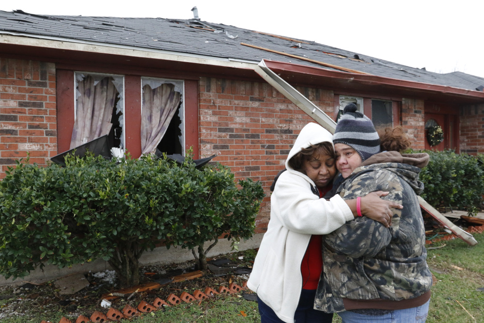 Roberta Moses, left, and Monica Holman embrace in Glenn Heights, Texas, on Monday.