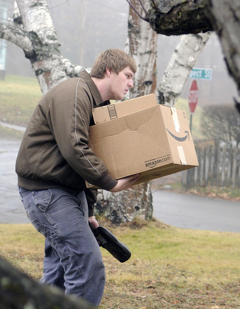 UPS driver helper Taylor Saulnier delivers a bundle of packages in Gardiner on Dec. 23.
