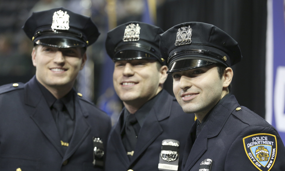 Brothers Stephan, left, John, center, and Alec Favale pose before the New York City Police Department Police Academy graduation ceremony Tuesday.