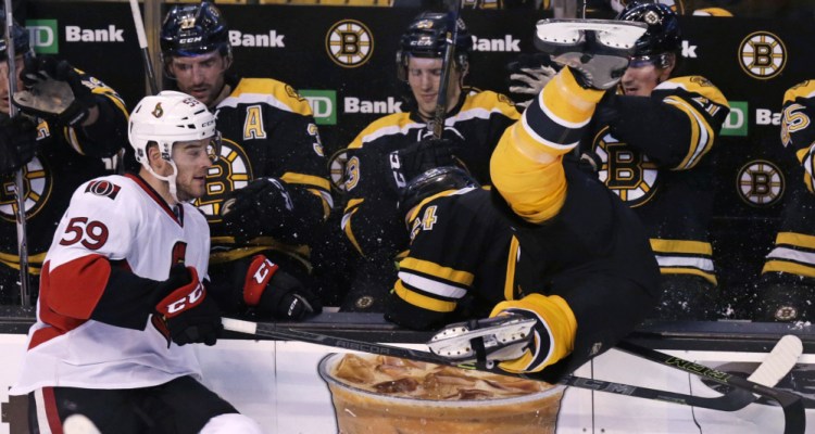 Senators left wing David Dziurzynski checks Bruins defenseman Adam McQuaid into the bench during the second period of what turned out to be a fight-filled game.
